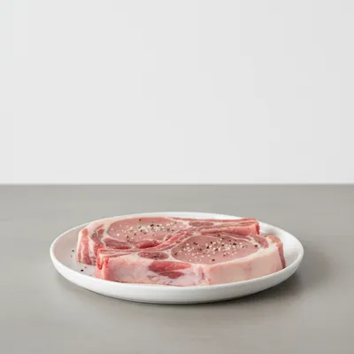 Raw pork chops on a plate