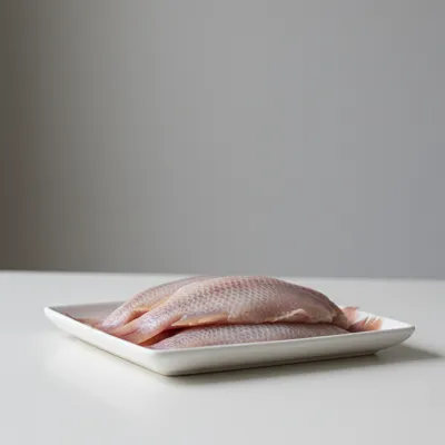 Raw tilapia fillets on a tray